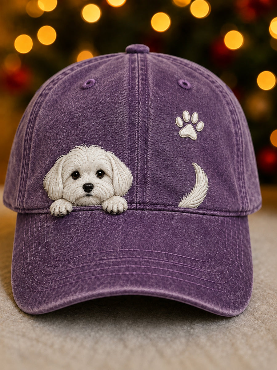 Washed purple baseball cap with a raised white puppy peeking over the brim, a paw print and a tail.