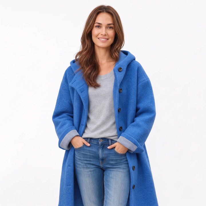 Studio shot of the blue hooded coat with striped cuffs, hands in jeans pockets 17