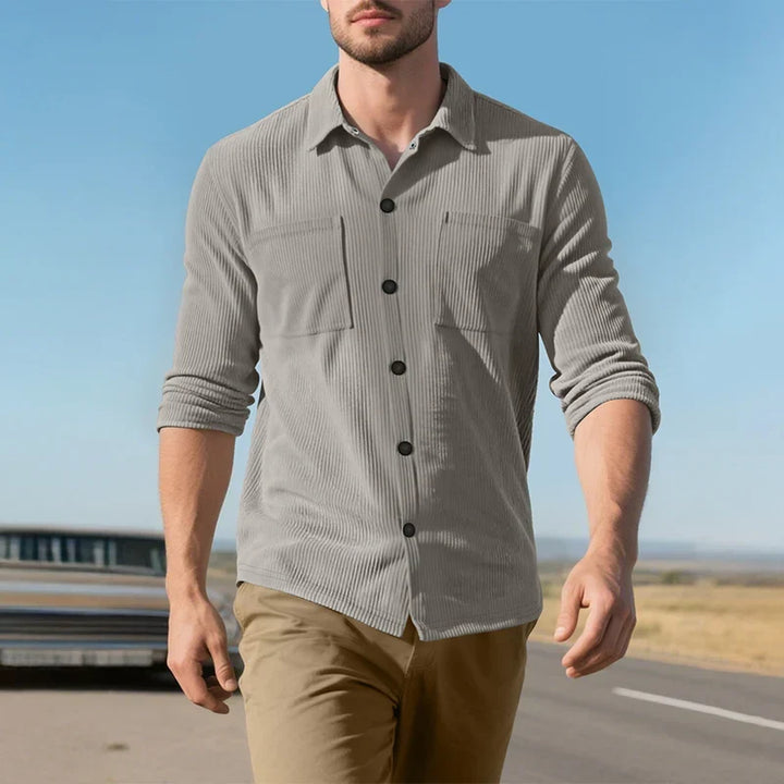 Model walking in the gray ribbed shirt with rolled sleeves on a road under a blue sky 18