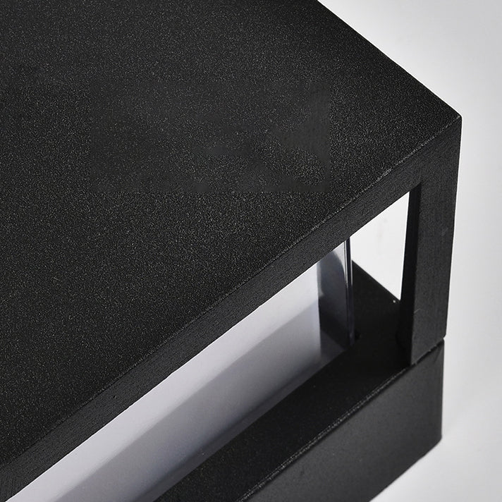 Close-up of the textured black metal frame corner of the lamp, showing the clear panel seen through the opening. 5