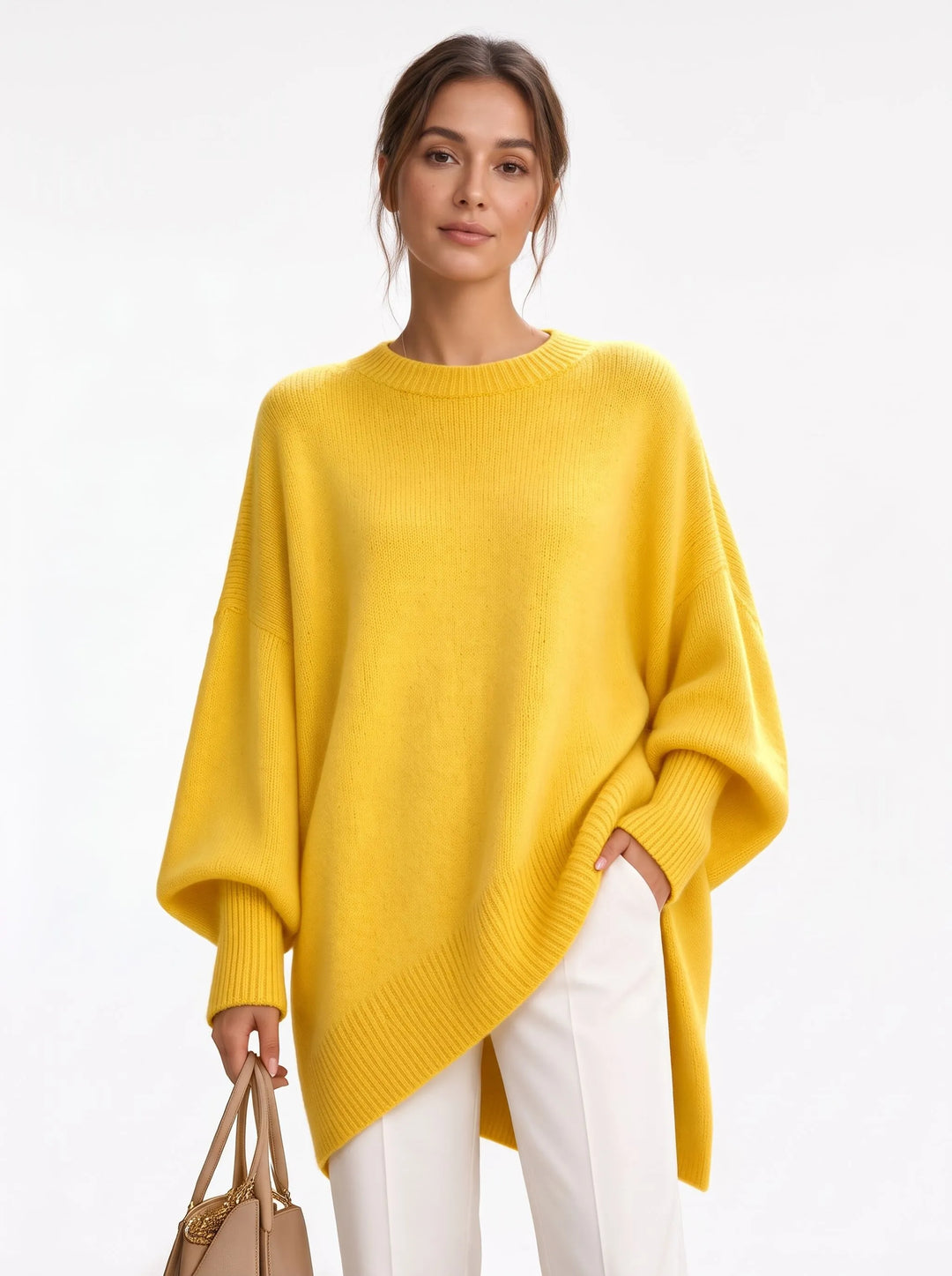 Studio shot of yellow oversized knit sweater with ribbed trim, white trousers and a tan handbag 18