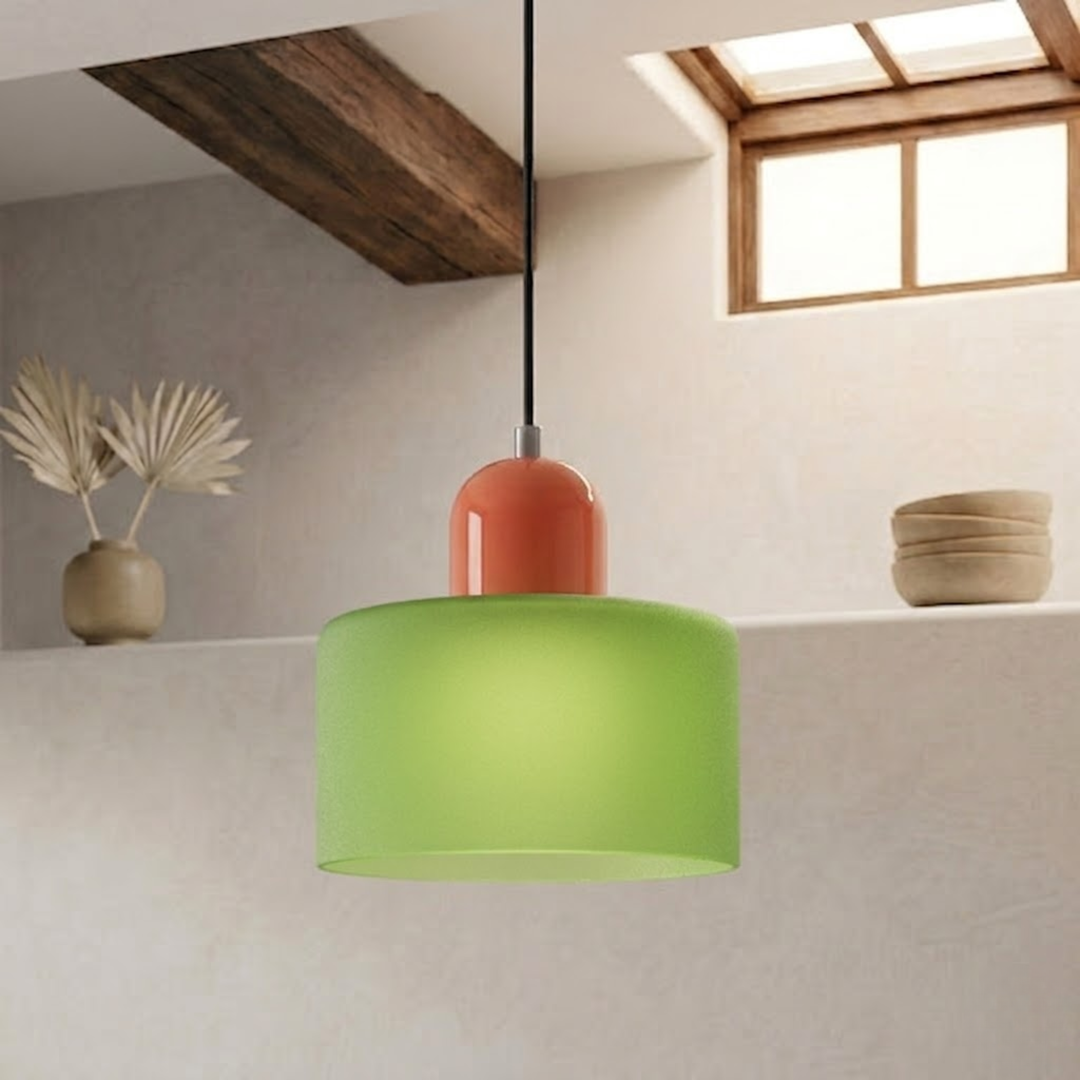 Frosted green drum shade paired with an orange dome cap hangs on a black cord in a rustic room. 24