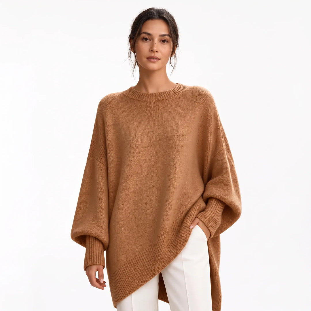 Studio shot of camel brown oversized knit sweater with ribbed cuffs, worn with white trousers 19