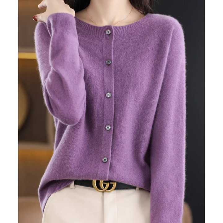 Woman wearing a lavender purple round-neck cardigan buttoned up the front, styled with cream pants and a black belt. 9