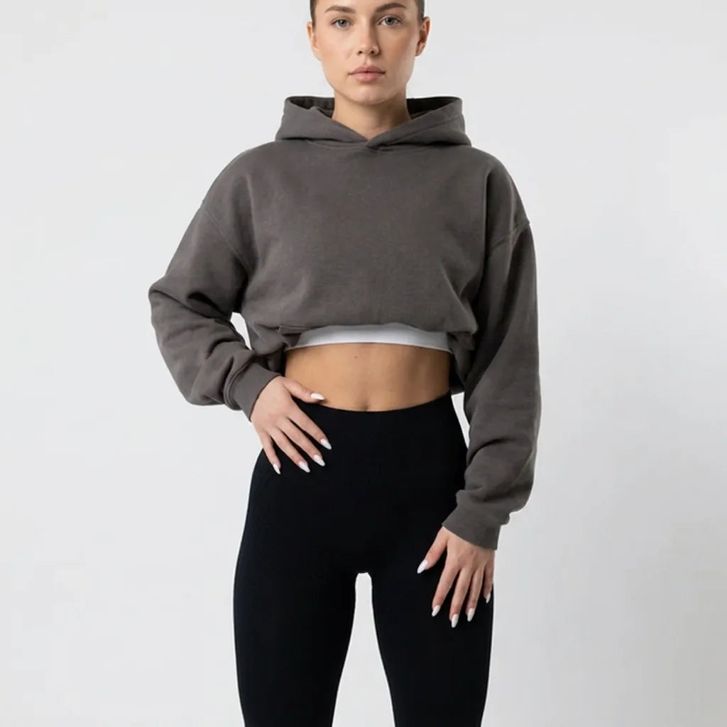 Close crop of the black high-waisted leggings at the waist, styled with a gray cropped hoodie and white top underneath. 6