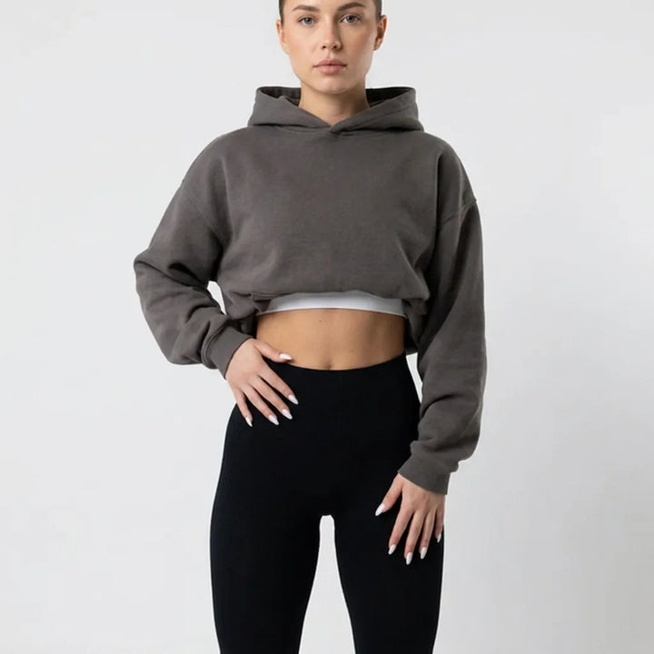 Close crop of the black high-waisted leggings at the waist, styled with a gray cropped hoodie and white top underneath. 6