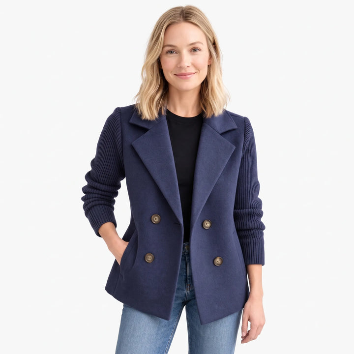 Navy jacket with ribbed knit sleeves worn open over a black top and jeans, studio shot 1