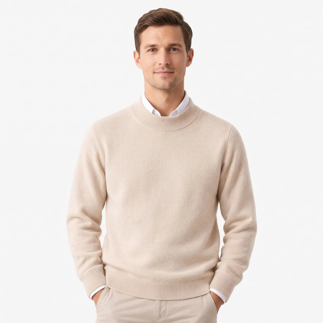 Man in a beige mock neck sweater over a white collared shirt, hands in pockets 1