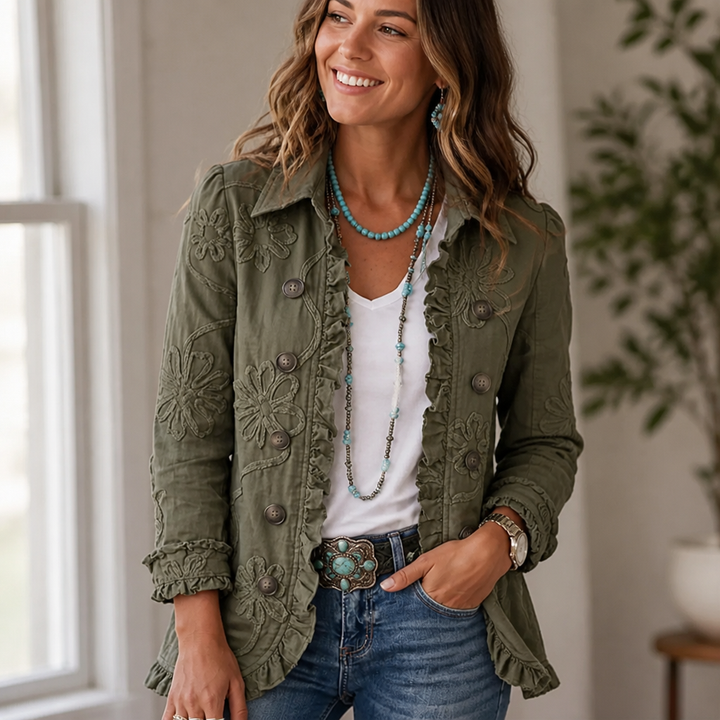 Green floral embroidered utility jacket worn over a white tee with jeans and turquoise jewelry.