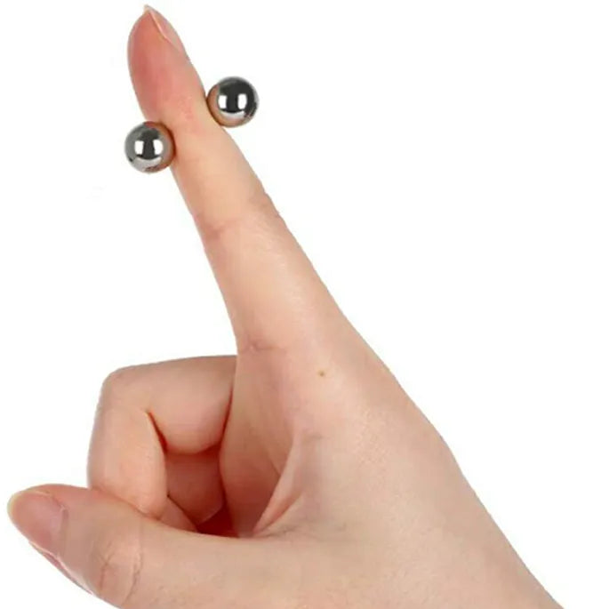 Raised finger with two small silver magnetic balls attached on opposite sides.