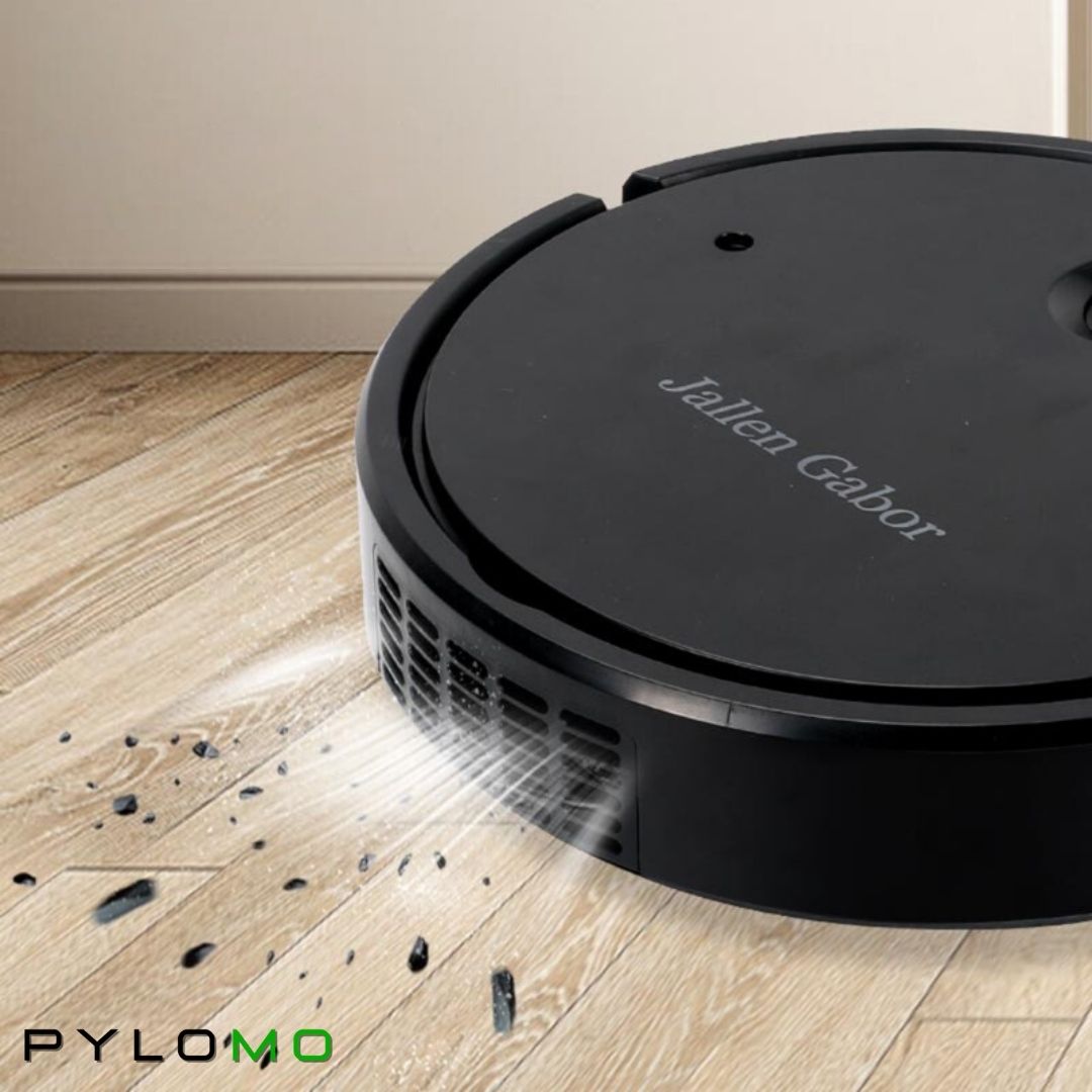 Close-up of a black robot vacuum sucking up debris from a wood floor beside its side vents 5