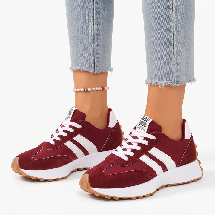 Burgundy suede and nylon platform trainers with white side stripes, worn with cropped light jeans and a pearl anklet 1