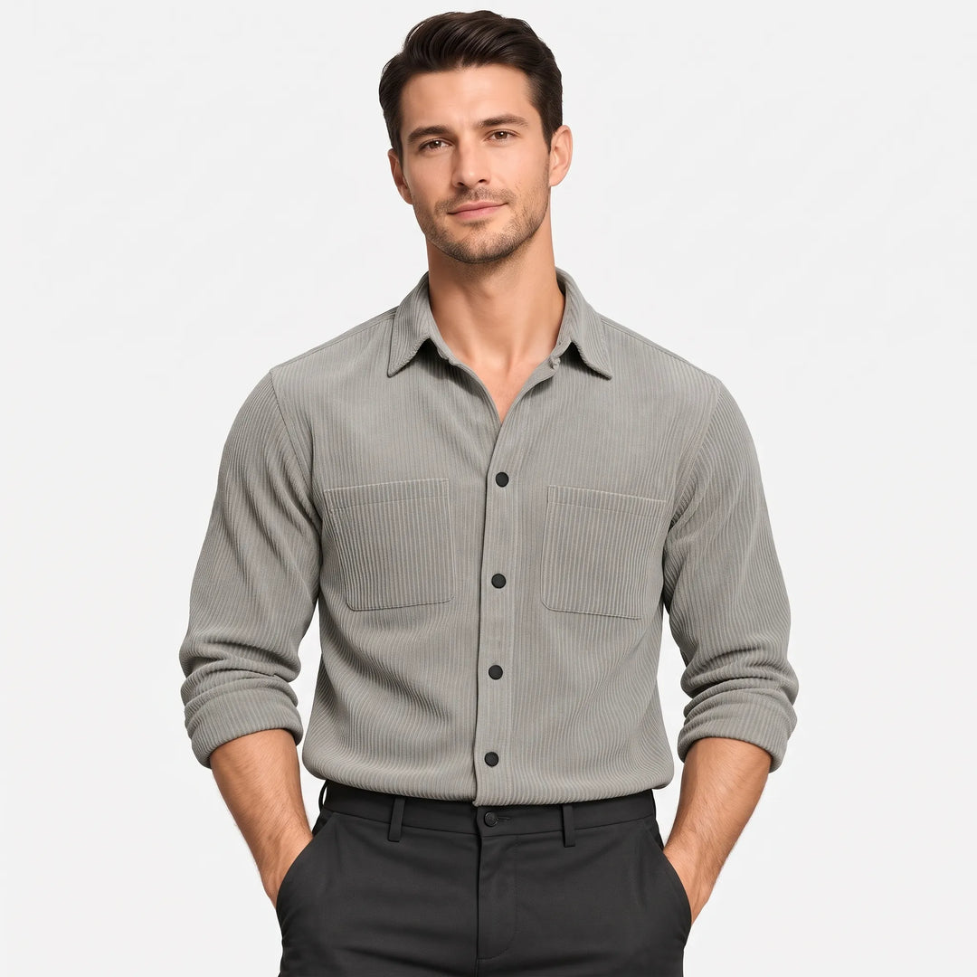 Model in a gray ribbed corduroy-style button shirt with two chest pockets, hands in dark trousers pockets 1