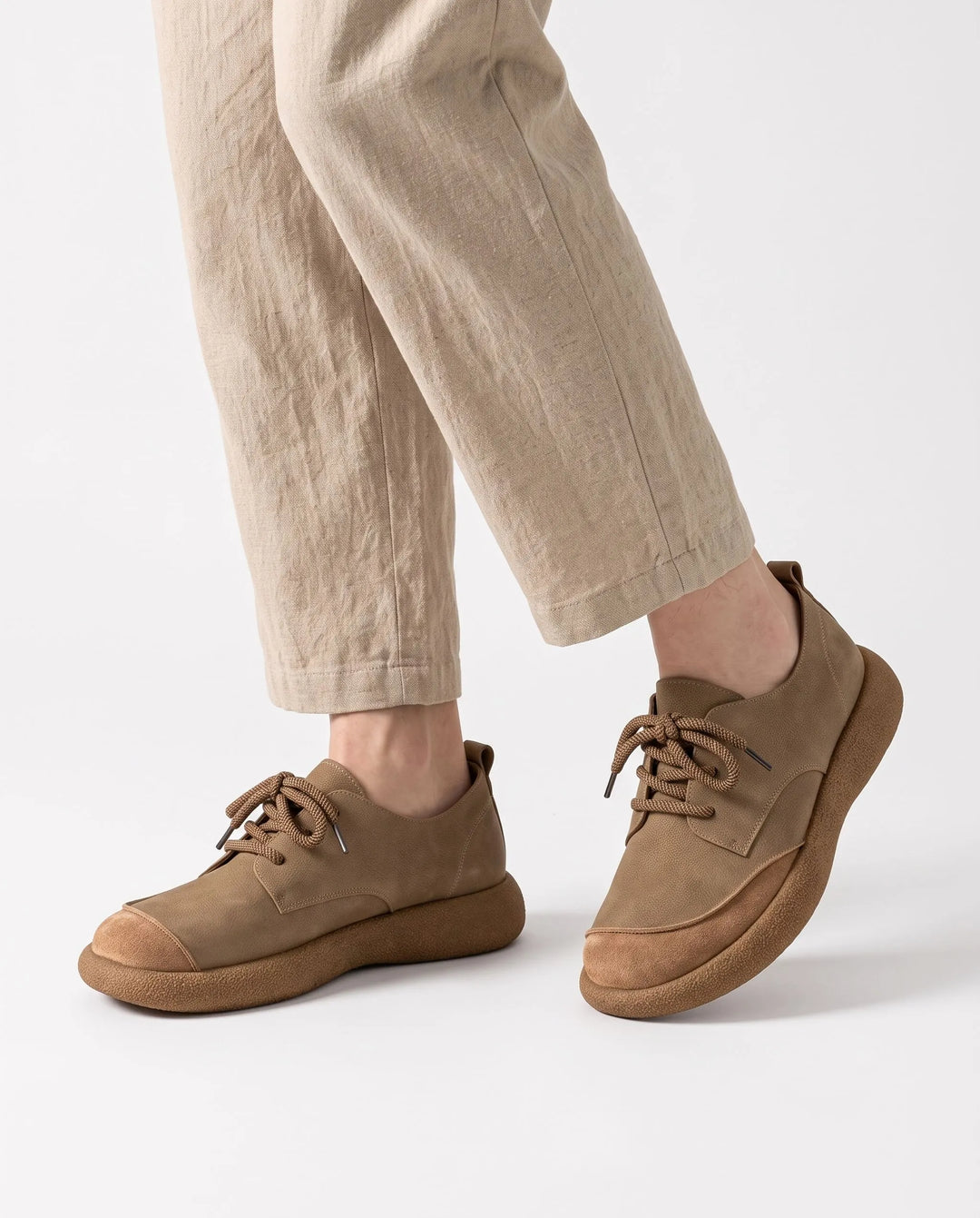 Tan lace-up shoes with a suede toe cap and thick sole, worn with linen trousers 1
