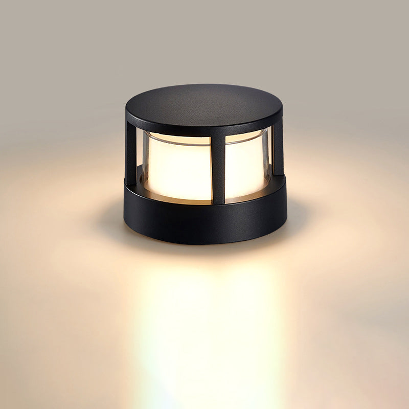 Round black lamp with a flat cap and caged frame, glowing warm white against a soft beige background. 8