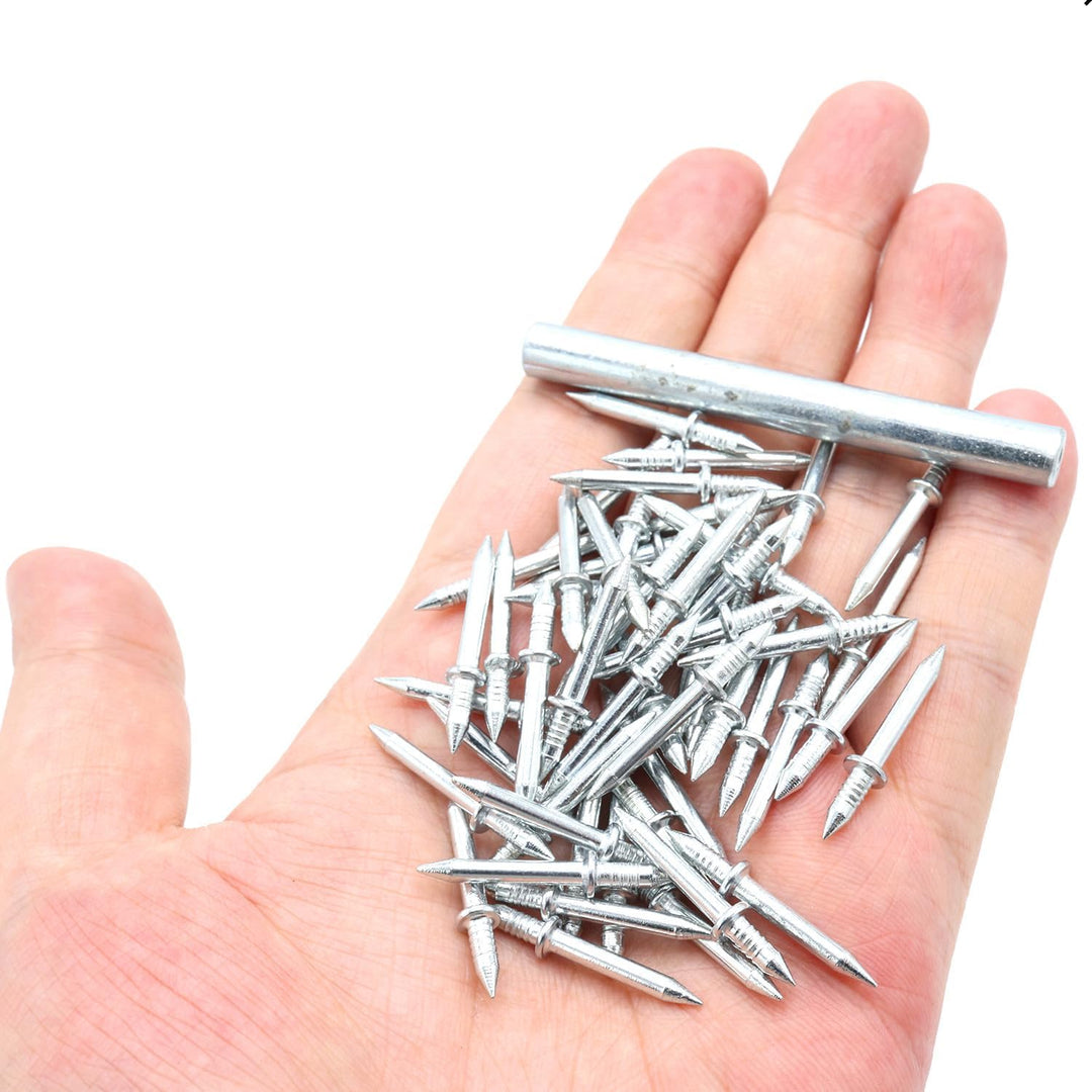 Silver double-head nails with a metal sleeve tool in an open palm.