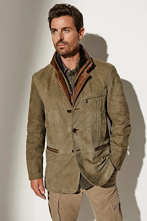 Model wearing the olive suede jacket buttoned over a dark shirt, with a brown leather collar liner and one hand in a pocket. 1