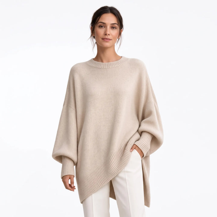 Studio shot of beige oversized knit sweater with ribbed hem and cuffs, worn with white trousers 20