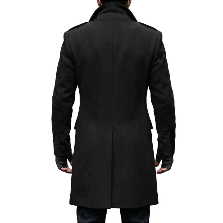 Back view of the black overcoat on a model, showing the center vent, collar and shoulder epaulettes 20