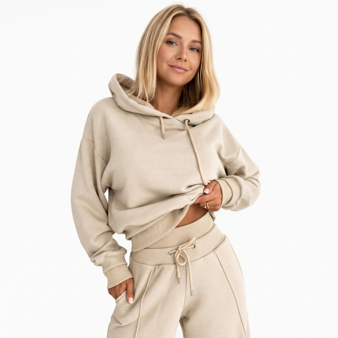 Model in a beige hooded sweatshirt and matching wide-leg pants, one hand in pocket, front view 21