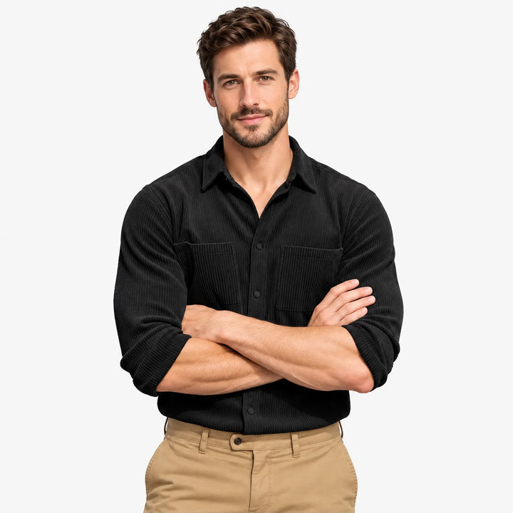 Man in a black corduroy button shirt with chest pockets, arms crossed, worn with khaki pants 21