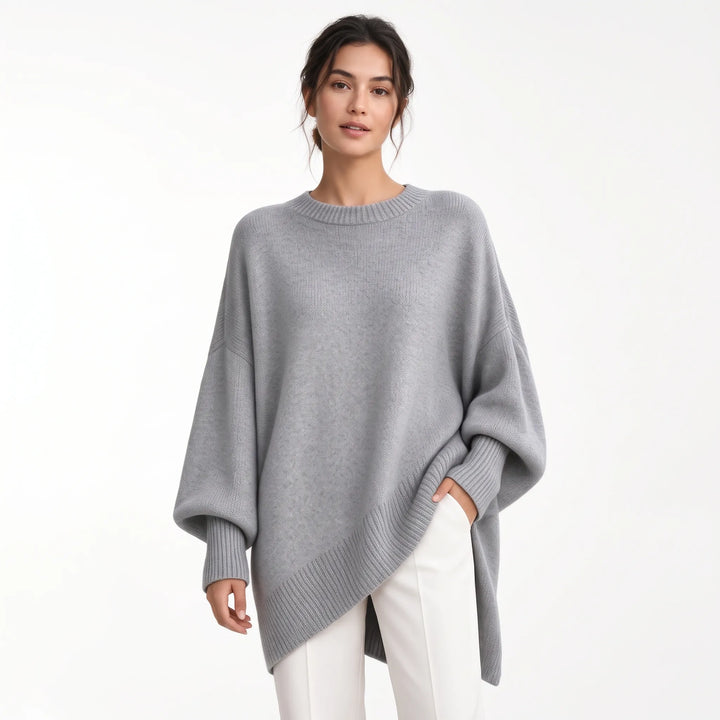 Woman wearing the oversized gray knit sweater with ribbed cuffs and hem, one hand in white trouser pocket 21
