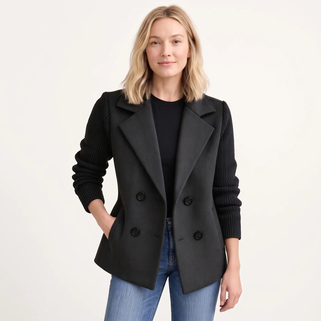 Woman wearing the black double-breasted jacket open over a black top and jeans, with ribbed knit sleeves 21