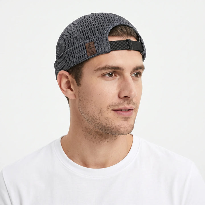 Man in a white tee wears the dark gray open-weave cap, showing its adjustable black rear strap 21