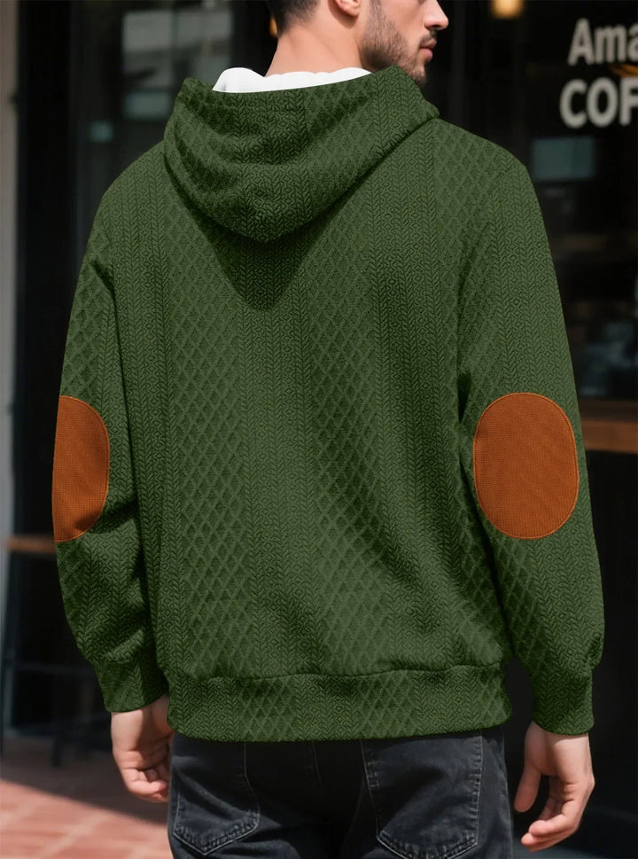 Back view of the olive green hoodie on a man, showing large brown elbow patches 23