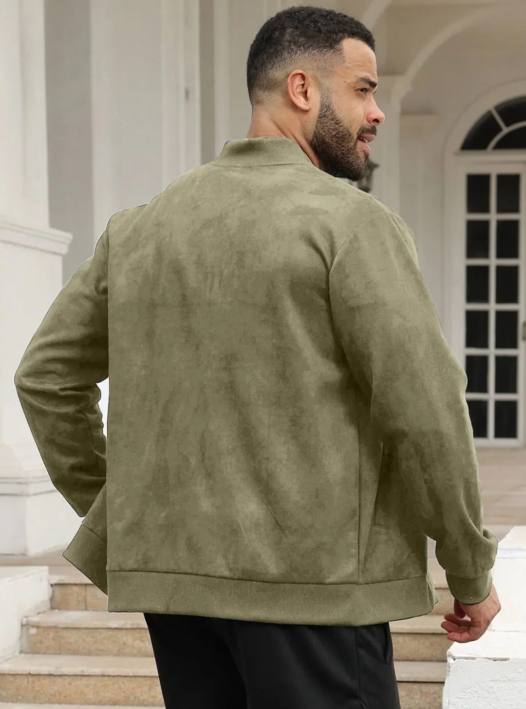 Man in olive green suede-look bomber jacket seen from behind, standing near white columns 24