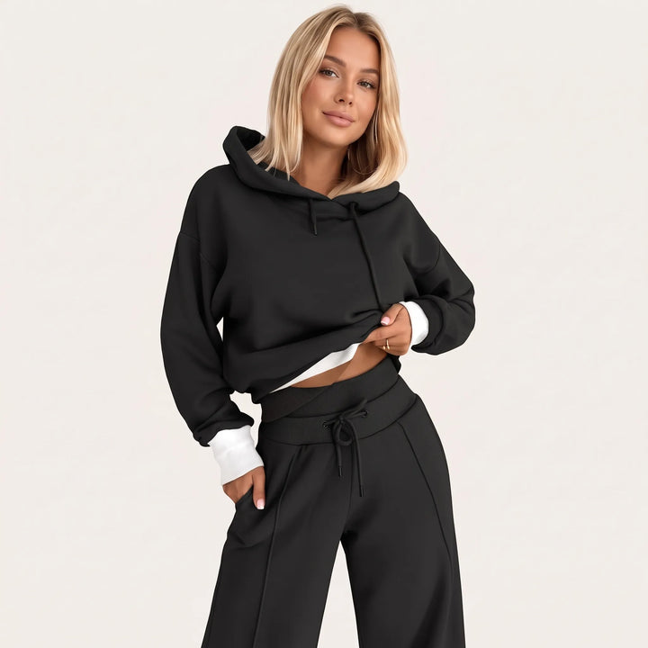 Model wearing the black hooded set with white ribbed hem and cuffs, front view 25
