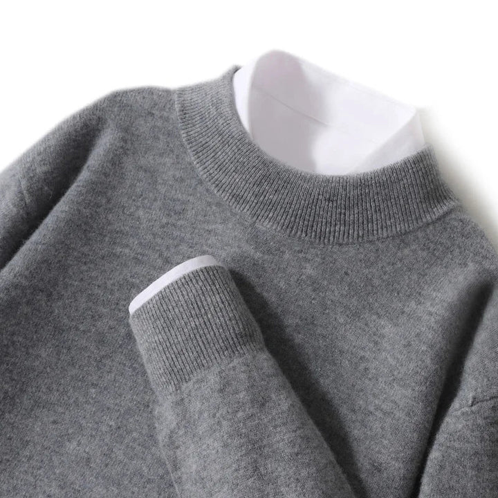 Close-up of the medium gray knit sweater's ribbed mock neck and cuff over a white shirt 25