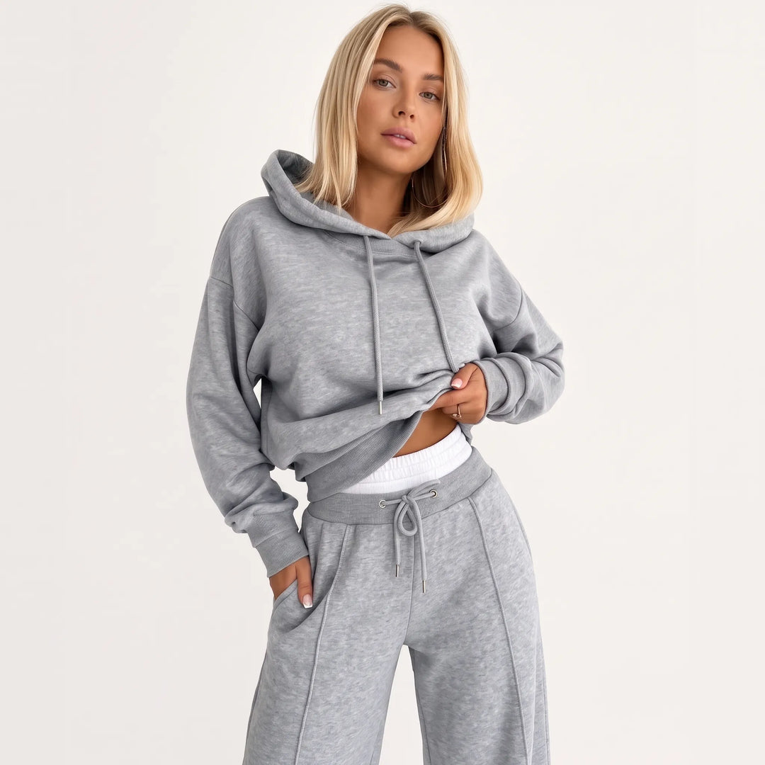 Model wearing the heather gray hooded set with a white waistband layer peeking out, front view 26