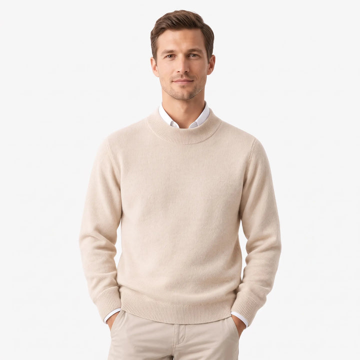 Man wearing the beige sweater over a white collared shirt with khaki pants, hands in pockets 27