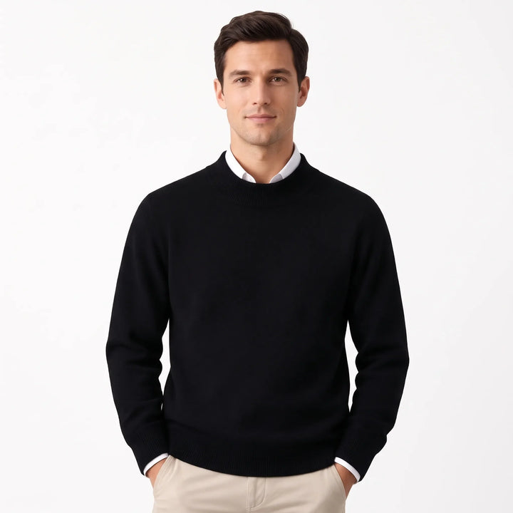 Man wearing the black sweater over a white collared shirt with khaki pants, hands in pockets 28