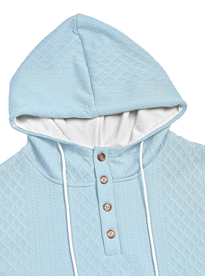 Close-up of the light blue textured hood and four-button placket with white drawstrings 28