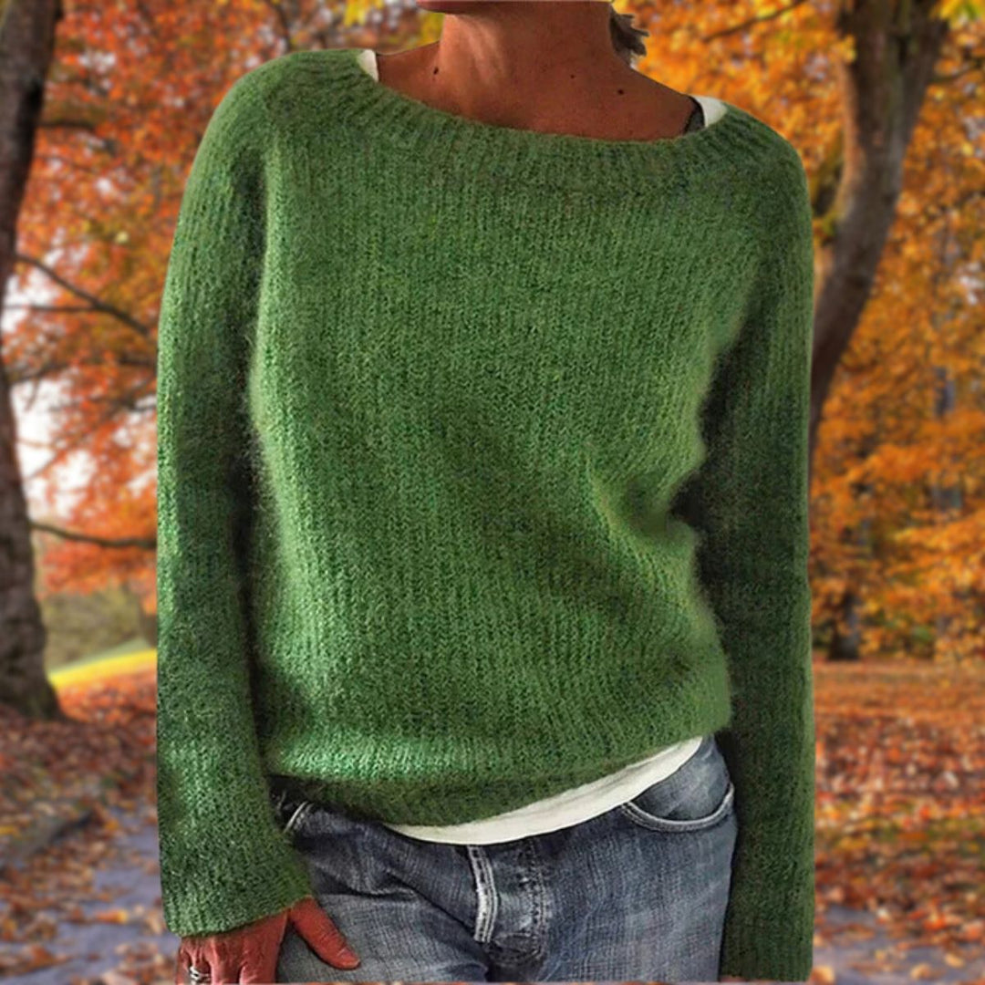 Green knit sweater with long sleeves, layered over a white tee with jeans against an autumn backdrop 5