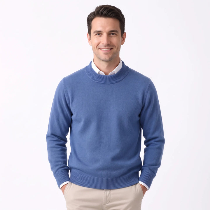 Smiling man wearing the medium blue sweater over a white collared shirt and khaki pants 29