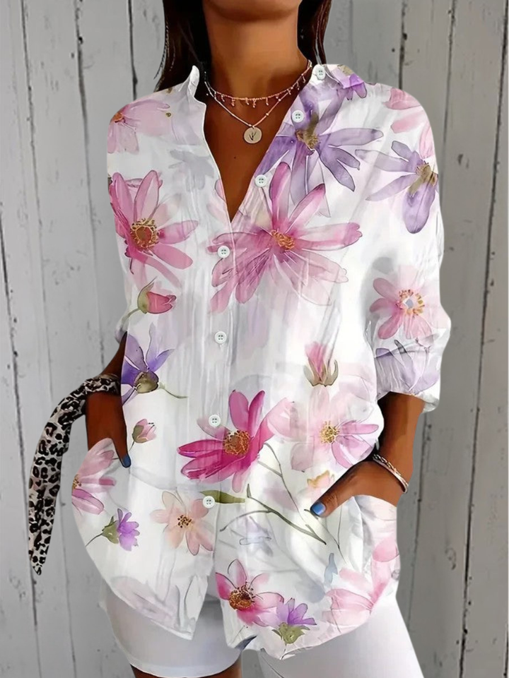Anica blouse detail with a white blouse and a soft watercolor print of pink and lavender daisy-like flowers.