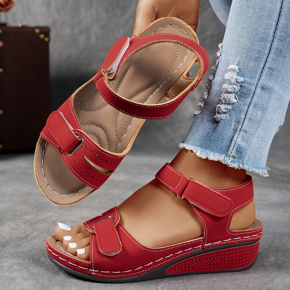 Red wedge sandal with contrast stitching and adjustable straps, with the footbed visible. 2