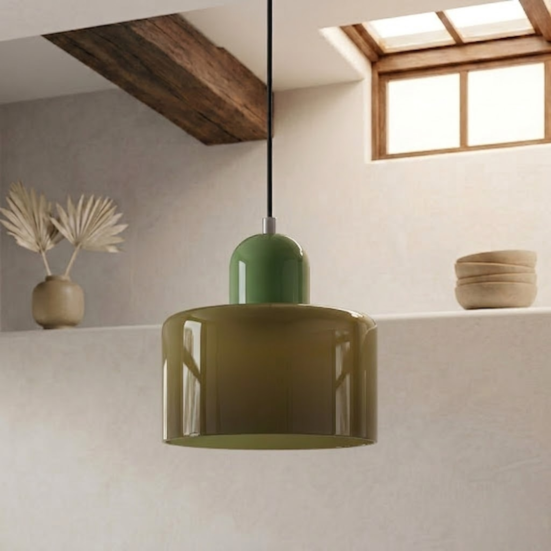 Olive-toned glass drum shade with a lighter sage green cap, hanging on a black cord beside a shelf of ceramics. 8