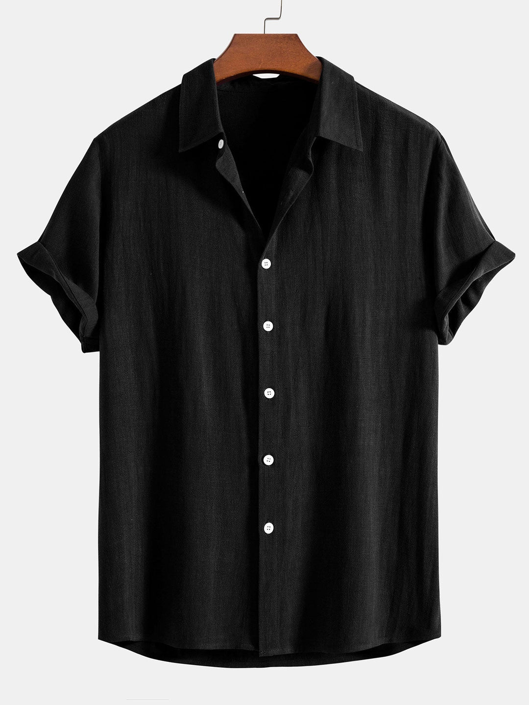 Black short sleeve shirt on a wooden hanger, front view with white buttons and cuffed sleeves.