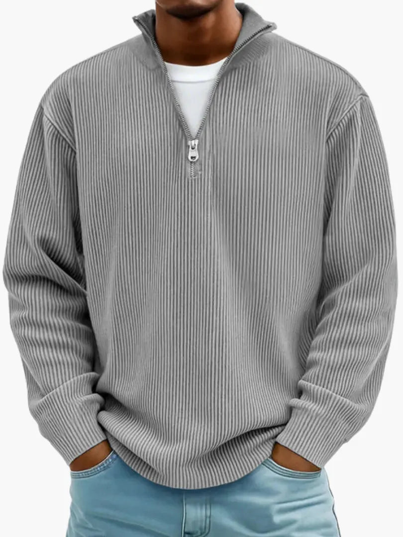 Man wearing the ribbed quarter-zip sweater in medium gray over a white tee, hands in jeans pockets.