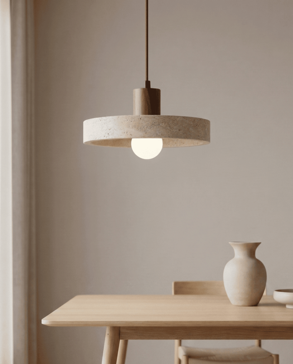 Travertine pendant light, another view, hanging above a light oak dining table.