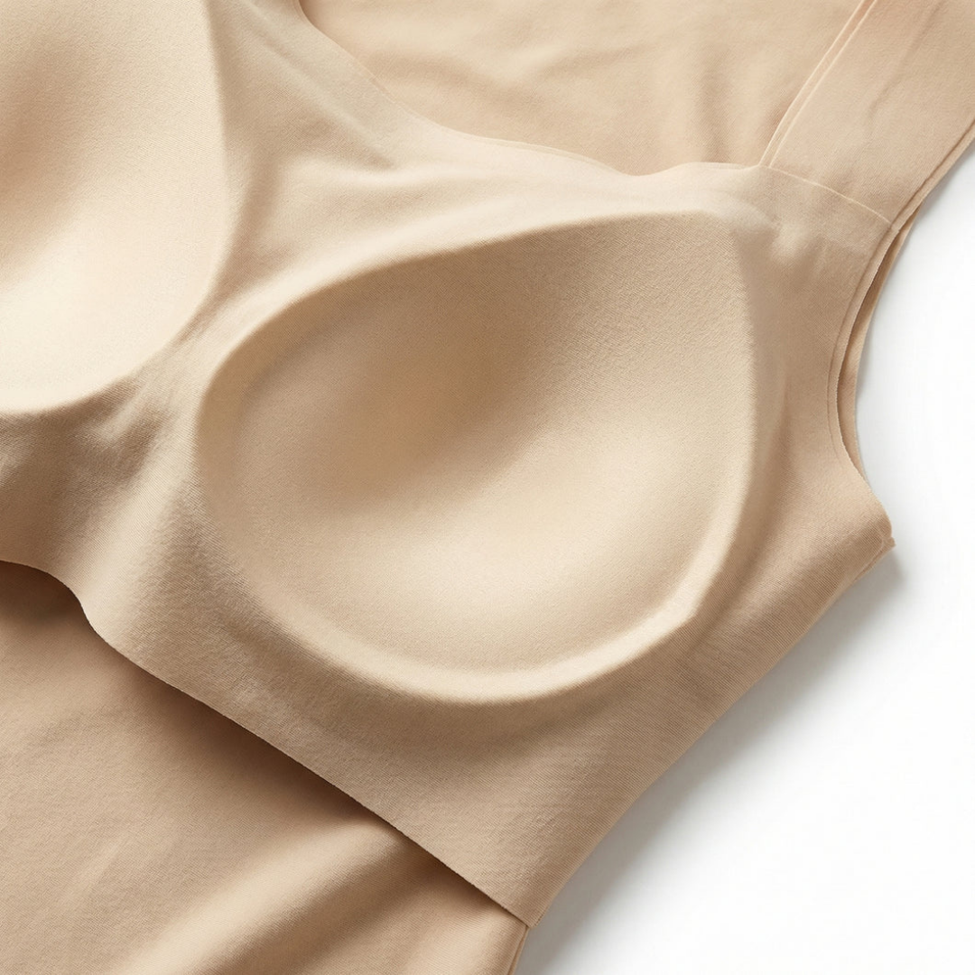 Close-up flat lay of the inside of a beige top showing the smooth molded bra cups built into the tank. 8