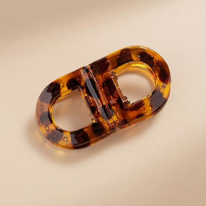 Flat Grip Magnetic Hair Clip in glossy tortoiseshell, shown from above on a cream background.