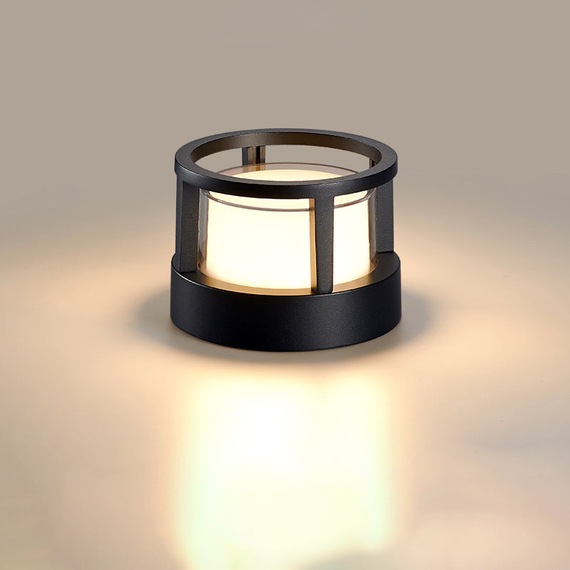 Round black lamp with an open ring top and caged frame, glowing warm white around a frosted cylinder diffuser. 9