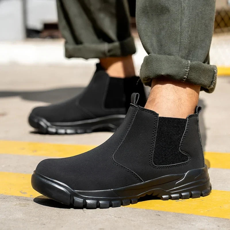 Close-up of black pull-on boots worn with rolled olive pants on pavement with yellow stripes 2