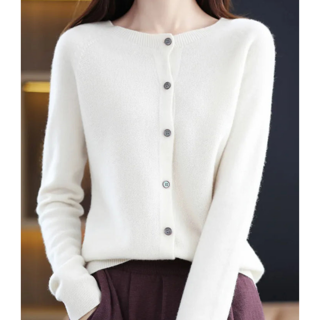 Woman wearing a white button-up round-neck knit cardigan with ribbed cuffs, styled with a burgundy skirt, hand tucked in pocket. 5