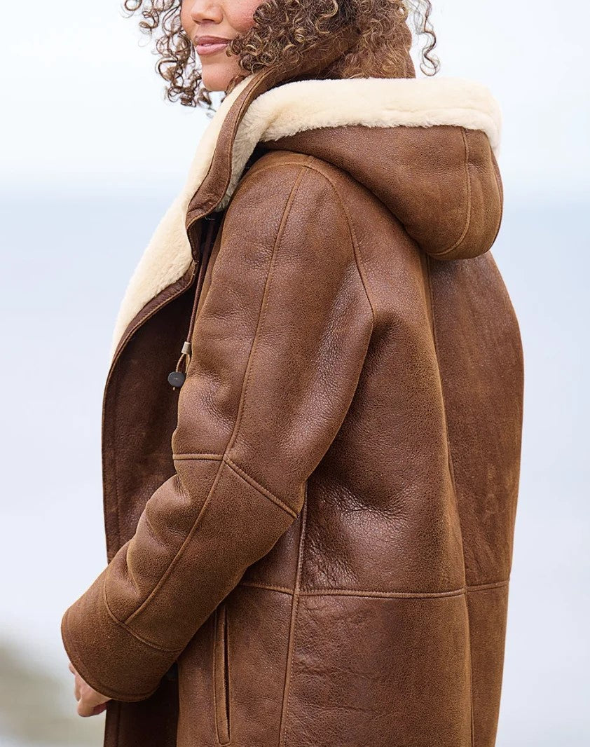 Brown coat with cream lined hood, shoulder seams and sleeve, side view.